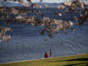 Two children walk Madison Park Beach after going for a dip in the water April 13, 2021.