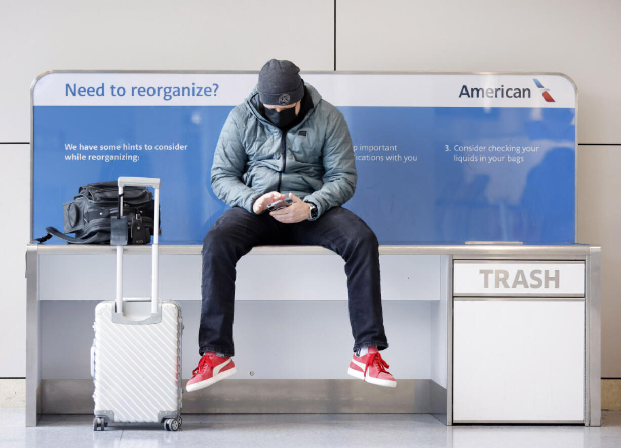 An American Airlines passenger listens to a conference call Feb. 23 as he waits for his flight in Terminal A at DFW Airport in Dallas.