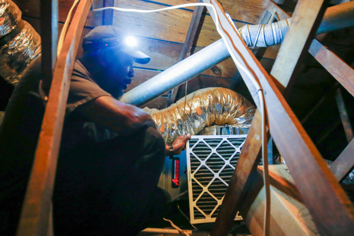 Darrell Word, technician and co-owner of Maintenance Unlimited Heating & Cooling, services an AC unit in College Park on Friday, July 28, 2023.