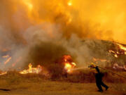 A firefighter battles the Fairview fire along Batista Road near Hemet, California, on Sep. 6, 2022.