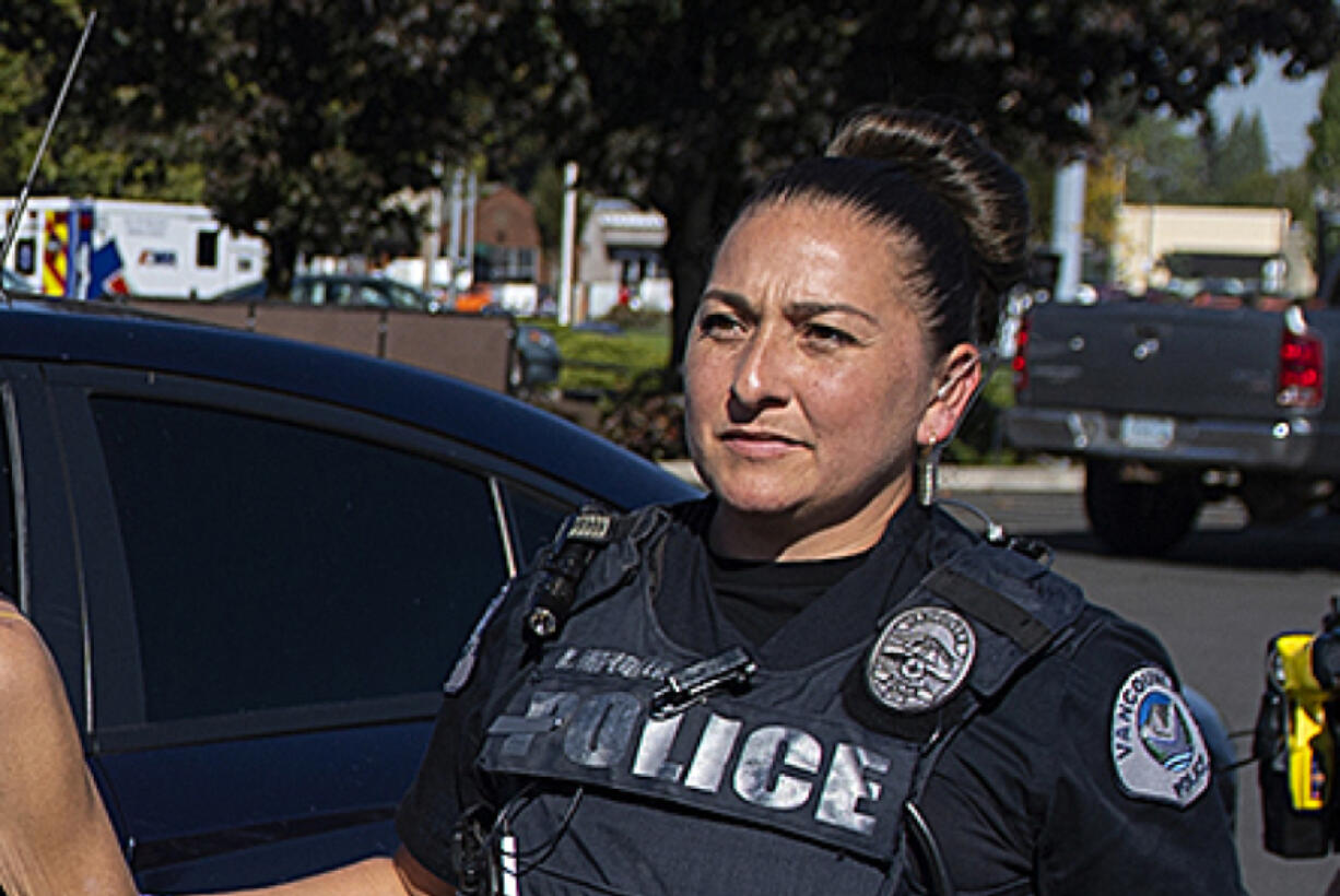 Officer Andrea Mendoza of the Vancouver Police Department escorts a suspected shoplifter into a patrol car Oct. 12, 2022, at the Fred Meyer store in Cascade Park. Mendoza is facing fourth-degree assault, a gross misdemeanor, after she was captured on video threatening to use her Taser on the genitals of a suspected shoplifter in May.