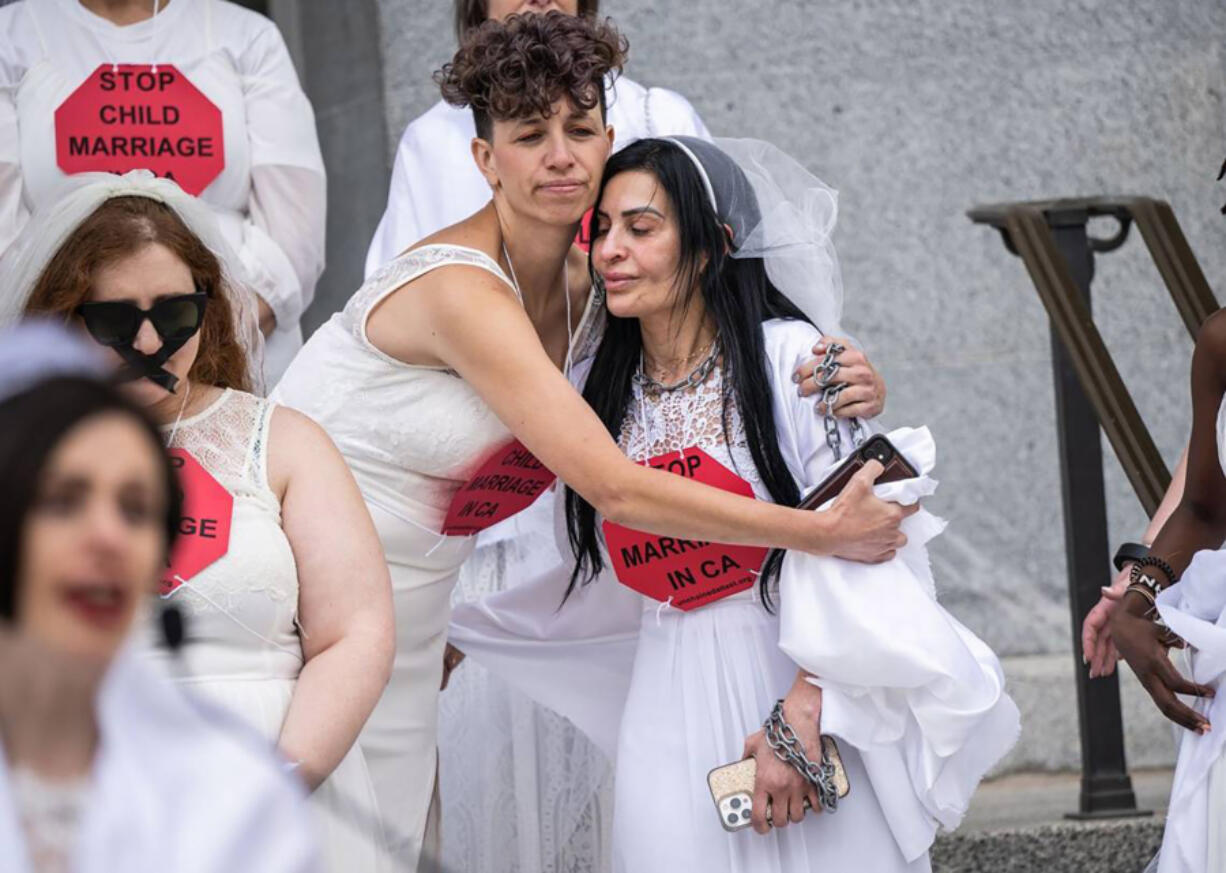 Chavie Weisberger on June 22, 2023, hugs fellow child marriage survivor Fatemah on the west steps of the California state Capitol as they told their stories during a rally against child marriage. The advocates and survivors are asking the Legislature for a bill that would prohibit child marriage in California.