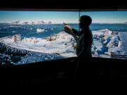 A professor of the British Antarctic Survey shows a picture of one of the bases in the Antarctic region of Polar Science for a Sustainable Planet, during a visit of the British Antarctic Survey's headquarters in Cambridge, on June 19, 2023, for the launch of the new 10-year BAS science strategy. With research stations transferring to renewable energy and artificial intelligence mapping out fuel-efficient marine routes, the British Antarctic Survey is putting sustainability at the heart of its new 10-year plan.