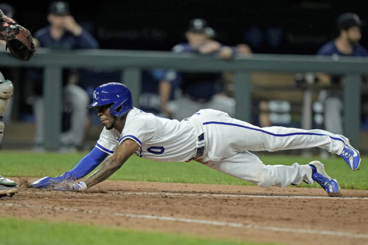 Kansas City Royals' Samad Taylor dives home to score the game-winning run on a bunt single by Dairon Blanco during the ninth inning of a baseball game Monday, Aug. 14, 2023, in Kansas City, Mo. The Royals won 7-6.