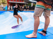 Crowds watch Beatriz Muniz of Seattle ride a wave at Lakeside Surf on June 13 in Chelan.