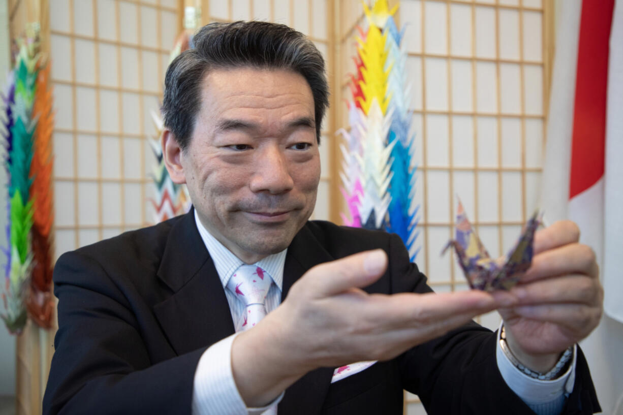 Hisao Inagaki, Japan's consul general in Seattle, displays a crane he folded Aug. 2 in Seattle. He's been folding an origami crane and recording a daily video, sending best wishes to Seattle residents, for almost three years.