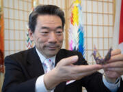 Hisao Inagaki, Japan's consul general in Seattle, displays a crane he folded Aug. 2 in Seattle. He's been folding an origami crane and recording a daily video, sending best wishes to Seattle residents, for almost three years.