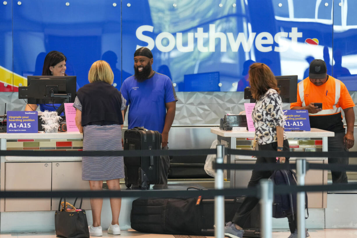 Southwest Airlines ticketing ramp agents work at a check in desk July 26 at Dallas Love Field Airport. (Smiley N.