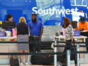 Southwest Airlines ticketing ramp agents work at a check in desk July 26 at Dallas Love Field Airport. (Smiley N.