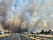 RETRANSMISSION TO CORRECT STATE - This photo provided by the Washington State Department of Transportation shows smoke from a wildfire burning south of Lind, Wash. on Thursday, Aug. 4, 2022. Sheriff's officials are telling residents in the town of Lind in eastern Washington to evacuate because of a growing wildfire south of town that was burning homes.