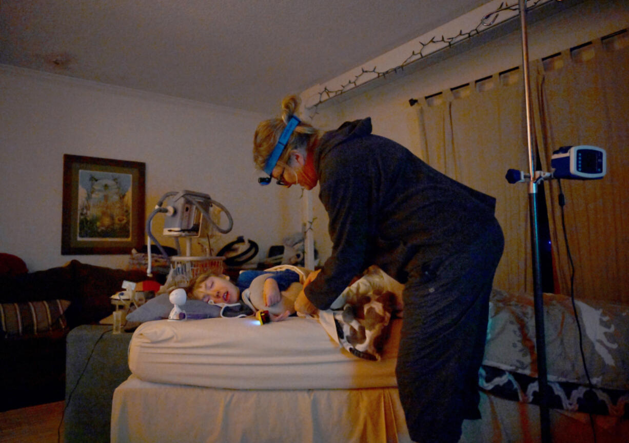 Amy Wiedeman gets her 12-year-old son Luke Schiller ready for bed at their home in Centennial, Colorado, on Jan. 31, 2023. Colorado's Medicaid agency is asking for more money for people who provide home care services for people like Luke, who has cerebral palsy and other illnesses that require around-the-clock care. Wiedeman said they've never been able to hire all the help Luke qualifies for, so she and her ex-husband take "night shifts" making sure Luke doesn't choke or have a seizure.