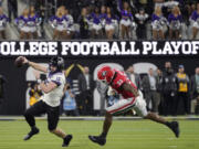 TCU quarterback Max Duggan (15) runs out of the pocket, chased by Georgia linebacker Robert Beal Jr. (33) during the second half of the national championship game Jan. 9, 2023, in Inglewood, Calif. The conference commissioners who manage the College Football Playoff met Wednesday, Aug. 30, 2023, for the first time since a wave of realignment tore apart the Pac-12, raising the possibility that the number of automatic bids in the 12-team postseason format to be implemented next year could be tweaked. (AP Photo/Mark J.