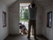 Michael Durkee, 15, left, holds a tape measure for Jeffrey Forbes, 60, at the Wayside Chapel along U.S. 2 in Monroe on June 24. Michael is leading the effort for his Eagle Scout project.