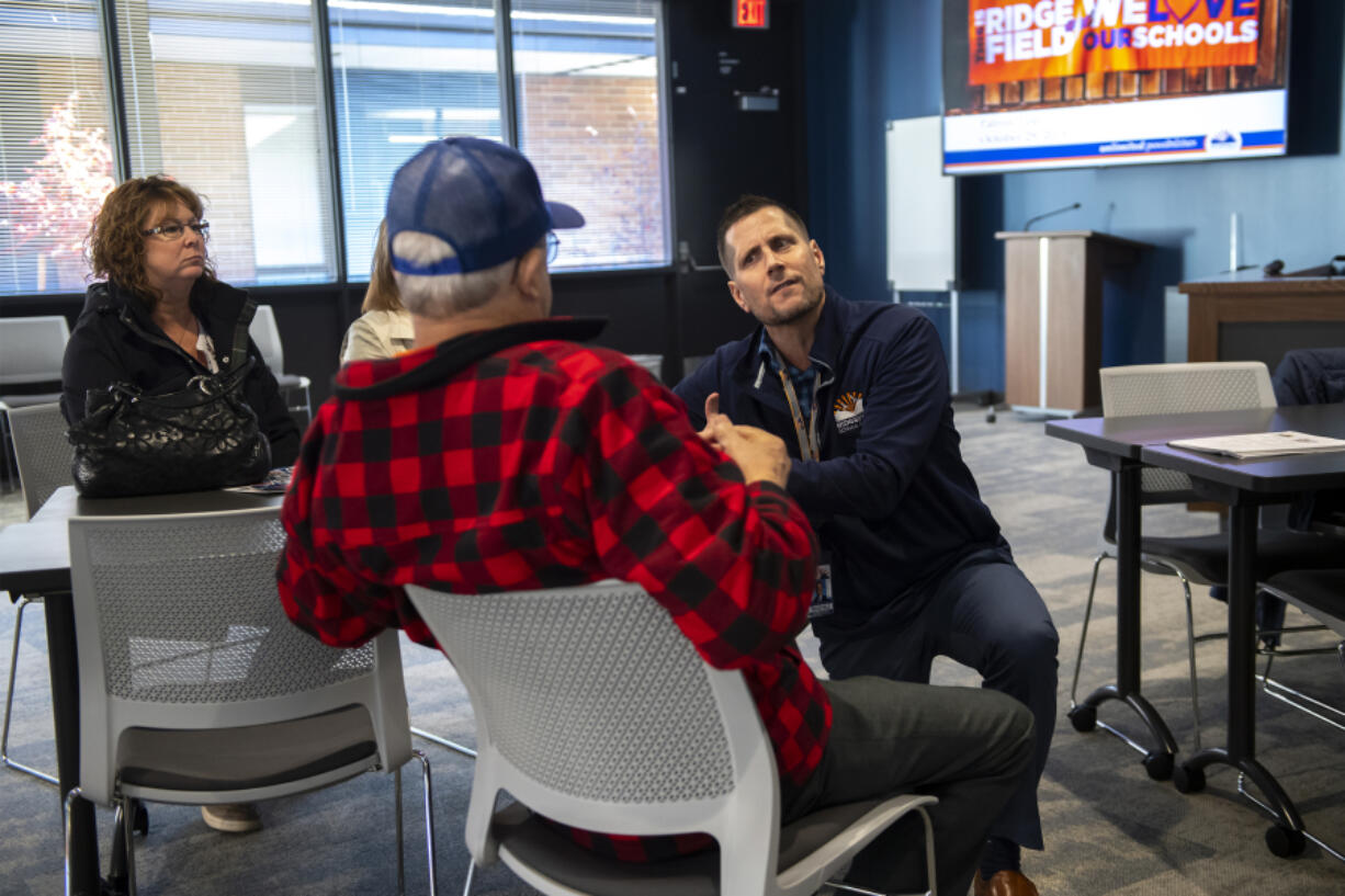 Ridgefield School District Superintendent Nathan McCann, right, speaks with a district resident about a bond issue in 2019. The district announced Wednesday that McCann tendered his resignation at the school board's meeting on Tuesday.