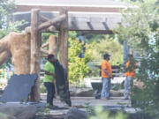 Workers install an artificial turf surface at Marshall Park. Though more expensive than wood chips, disability advocates say plastic turf is a key to making playgrounds more accessible.