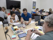 Dani Jamison of Union High School, left in white, works with Shane Heideman of Colville High School as they dissect a power strip in the physics room Wednesday afternoon. Teachers from across Washington this week are converging on Educational Service District 112's headquarters in Vancouver to receive new or continued training on OpenSciEd, a highly successful project-based science curriculum gaining interest in the state.