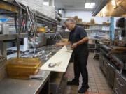 Restaurateur Genaro Zurita Amaro helps prepare for the lunch rush in the kitchen at Gustav's in east Vancouver. Zurita Amaro got his start at a German restaurant in Portland.