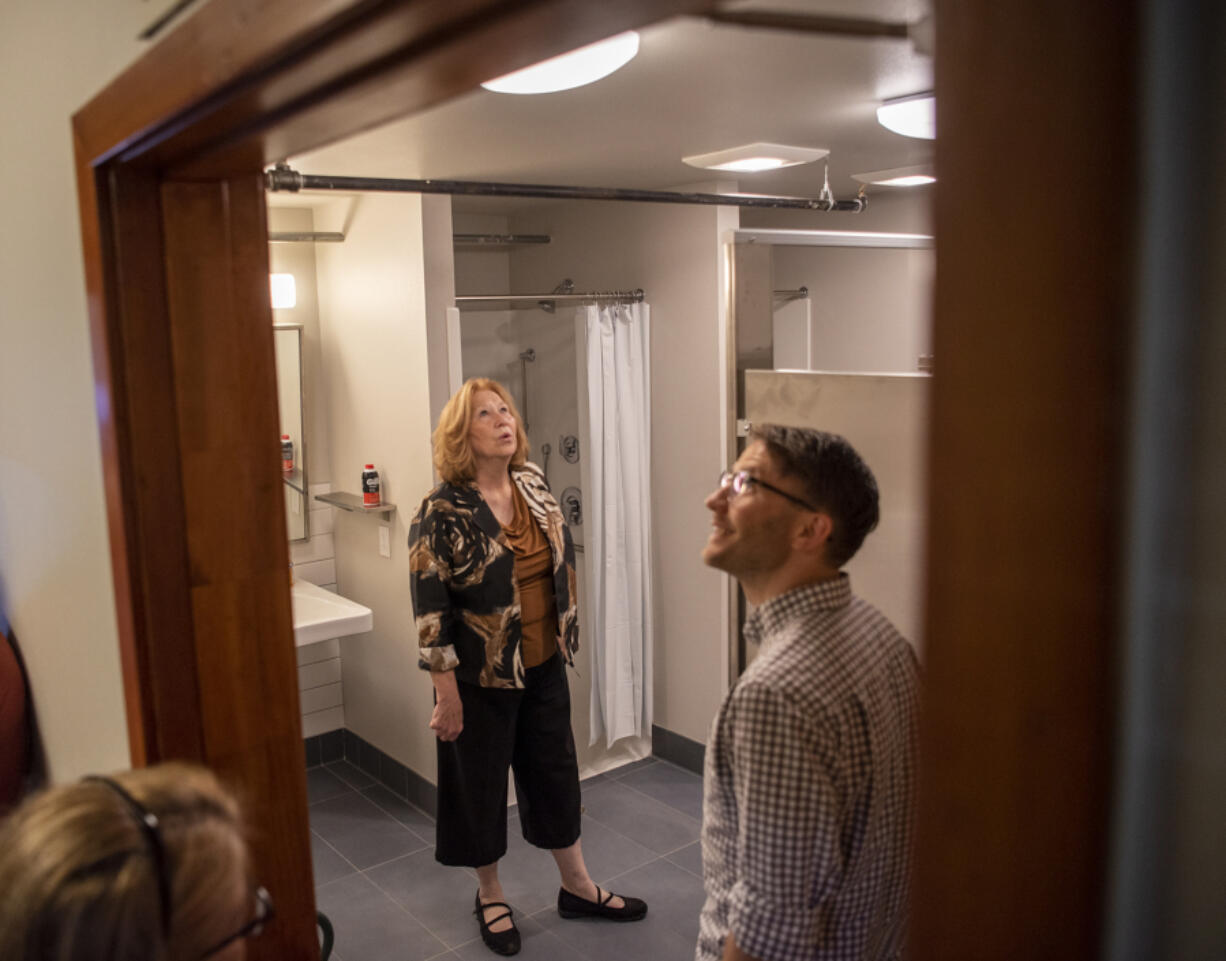 Vancouver Mayor Anne McEnerny-Ogle, center, and LSW architect Jacob DeNeui examine the redesigned bathroom at the men's shelter at St. Paul Lutheran Church.