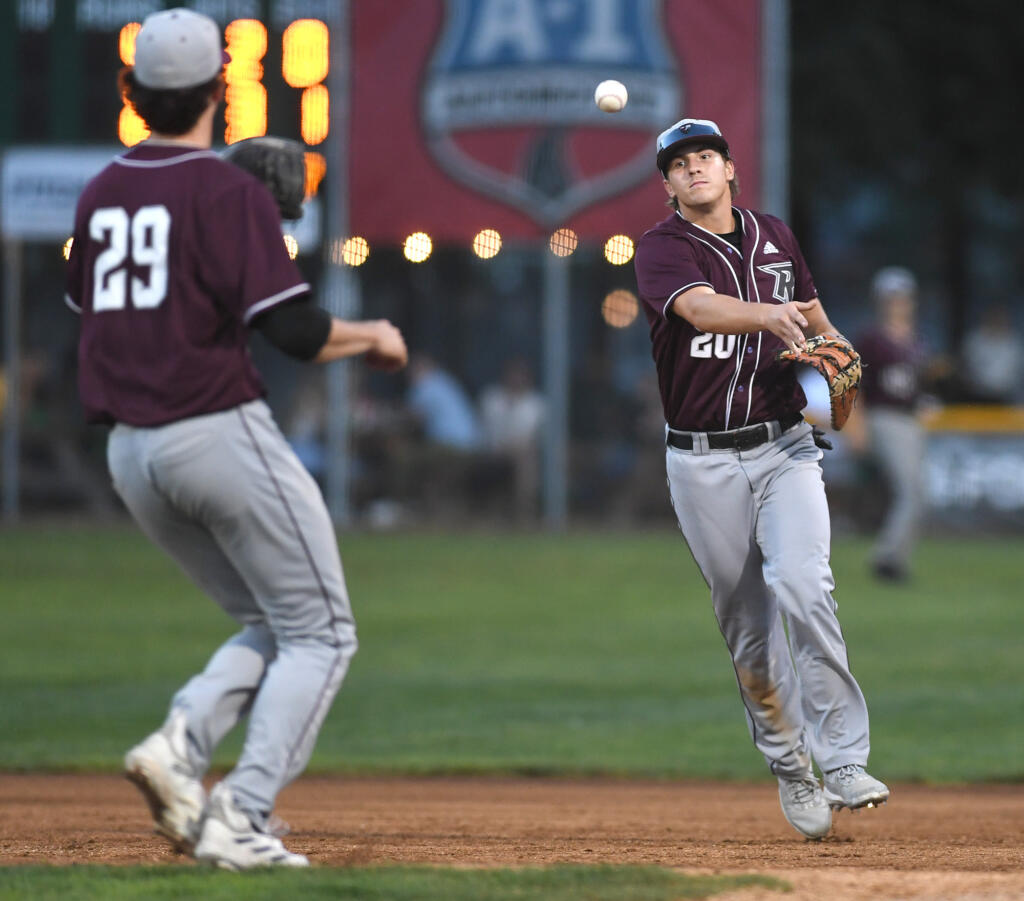 Raptors player Nick Holm, right, flips the ball to pitcher Charlie Royle on Tuesday, Aug. 8, 2023, during the Raptors’ 10-6 loss to the Pickles in the first game of the WCL Divisional Series at Walker Stadium in Portland.