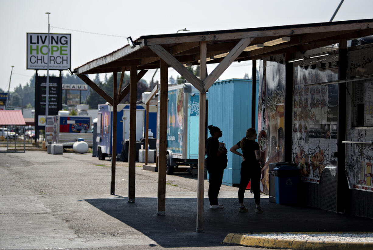 Customers take a minute to decide their lunch order while visiting the food carts at Living Hope Church on Northeast Andresen Road.