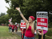 Camas High School teacher Ruhiyyih Wittwer, cq, red scarf, greets a motorist as she joins fellow educators and supporters during a district wide strike outside Camas High School on Monday morning, Aug. 28, 2023. The strike postponed the first day of school in the district.