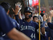 Seattle Mariners' Julio Rodriguez (44) celebrates in the dugout after hitting a home run during the fourth inning of a baseball game against the Los Angeles Angels in Anaheim, Calif., Friday, Aug. 4, 2023. J.P. Crawford also scored.