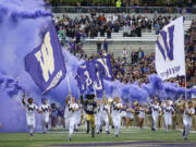 FILE - Washington cheerleaders and Harry, the Husky mascot, set off smoke effects as they lead the team out of the tunnel at Husky Stadium for Washington's home opener, an NCAA college football game against Montana, Saturday, Sept. 9, 2017, in Seattle. Dealing a crushing combination to the Pac-12 on Friday, Aug. 4, 2023, the Big Ten announced Oregon and Washington would be joining the conference next August, and the Big 12 completed its raid of the beleaguered league by adding Arizona, Arizona State and Utah.  (AP Photo/Ted S.