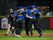 Seattle Mariners, including first baseman Ty France (23), third baseman Eugenio Suárez, center facing, and relief pitcher Andres Munoz (75) dance after the team's win over the Kansas City Royals in a baseball game Friday, Aug. 25, 2023, in Seattle.