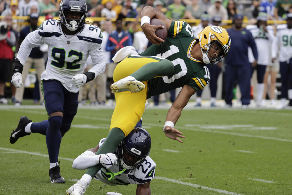 Green Bay Packers quarterback Jordan Love (10) is tackled by Seattle Seahawks cornerback Artie Burns (23) in the first half of a preseason NFL football game, Saturday, Aug. 26, 2023, in Green Bay, Wis.