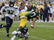 Green Bay Packers quarterback Jordan Love (10) is tackled by Seattle Seahawks cornerback Artie Burns (23) in the first half of a preseason NFL football game, Saturday, Aug. 26, 2023, in Green Bay, Wis.