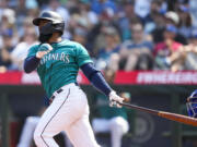 Seattle Mariners' Teoscar Hernandez follows through on a grand slam against the Kansas City Royals during the third inning of a baseball game Saturday, Aug. 26, 2023, in Seattle.