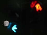 A supermoon is framed by the lights of a semaphore in Rome, Wednesday, Aug. 30, 2023.