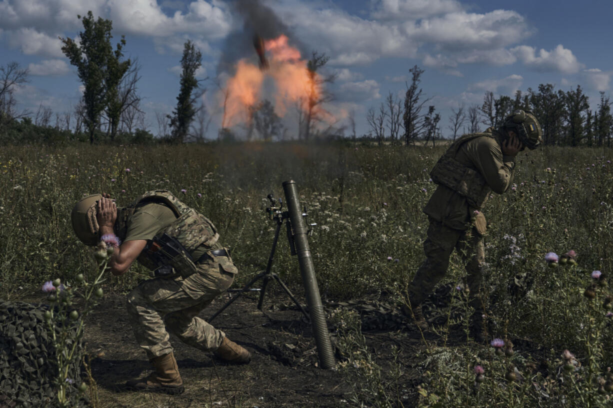 Ukrainian soldiers fire a mortar towards Russian positions at the front line, near Bakhmut, Donetsk region, Ukraine, Saturday, Aug. 12 2023.