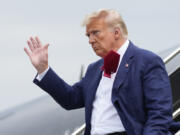 FILE - Former President Donald Trump waves as he steps off his plane at Ronald Reagan Washington National Airport, Aug. 3, 2023, in Arlington, Va. A slim majority of Americans approve of the U.S. Justice Department indicting Trump over his efforts to remain in office after losing the 2020 election, according to a new poll from The Associated Press-NORC Center for Public Affairs Research.