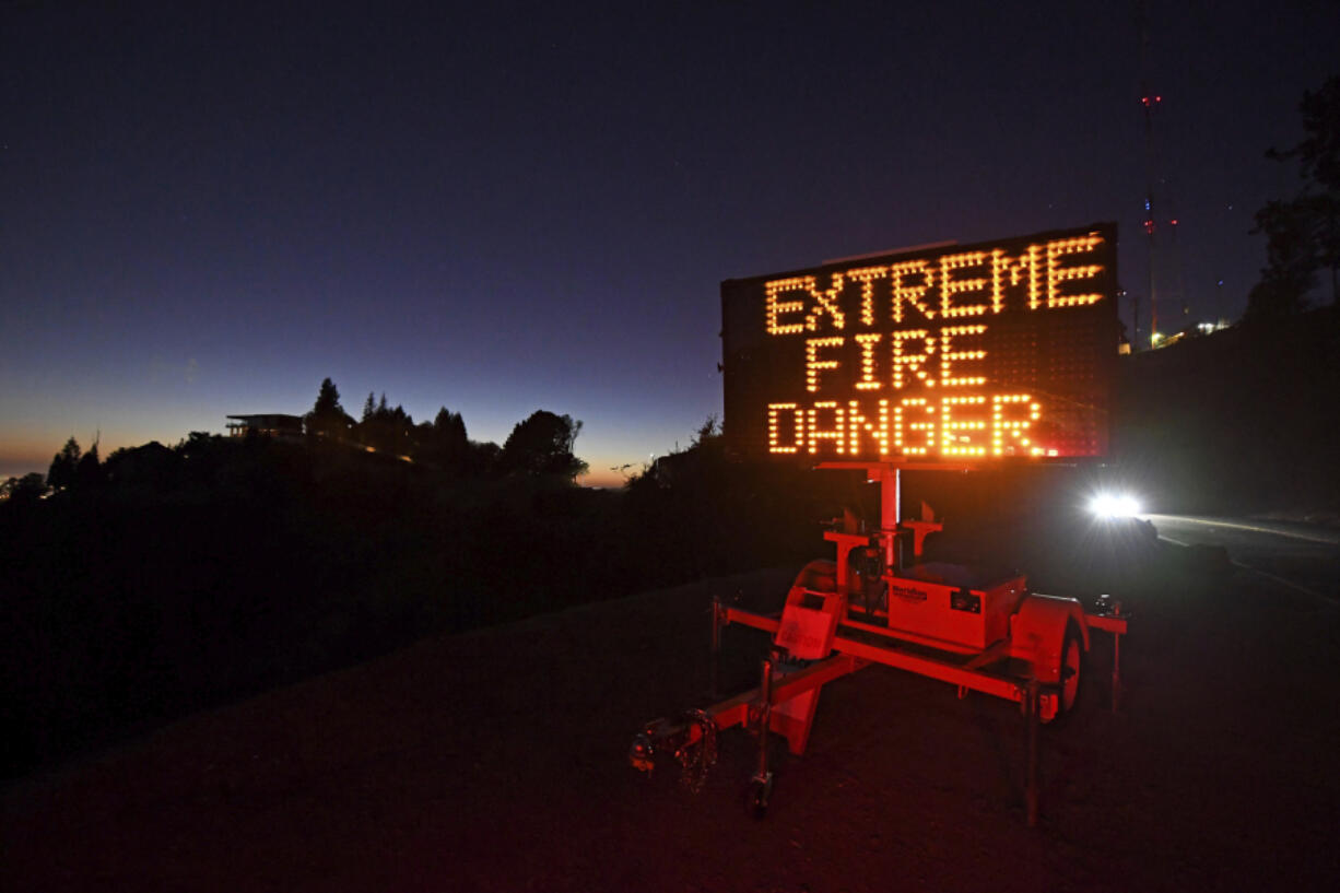 FILE - A roadside sign warns motorists of extreme fire danger on Grizzly Peak Boulevard, in Oakland, Calif., on Oct. 25, 2020. Critical fire weather conditions were developing in the interior of Northern California, forecasters said Tuesday, Aug. 29, 2023, and a utility planned to cut power to parts of eight counties to prevent ignitions if wires are downed or damaged.