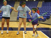 Anya Rhodes, 8, of Newton Mass., right, plays a game with a hula hoop July 14 during Camp No Limits at Quinnipiac University in Hamden, Conn.