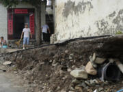 Residents try to restore normalcy to their lives near underground pipes exposed after floods sweep through a village on the outskirts of Beijing, Friday, Aug. 4, 2023. Heavy rain and high water levels on rivers in northeastern China were threatening cities downstream on Friday, prompting the evacuation of thousands, although the country appears to have averted the worst effects of the typhoon season battering parts of east Asia.