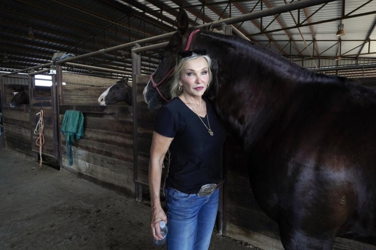 Ranch owner Gilda Jackson poses for a photo as she works with one of her horses in the arena on her property in Paradise, Texas, Monday, Aug. 21, 2022. The Texas ranch where Jackson trains and sells horses has been plagued by grasshoppers this year, a problem that only gets worse when the hatch quickens in times of heat and drought. Jackson watched this summer as the insects chewed through a 35-acre pasture she badly needs for hay and what they didn't destroy, the sun burned up.