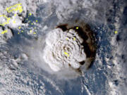 FILE - This satellite image made by the Japanese weather satellite Himawari-8 shows the eruption of the Hunga Tonga-Hunga Ha'apai undersea volcano at the Pacific nation of Tonga on Jan. 15, 2022. Scientists say by far the biggest cause of the recent extreme warming is human-caused climate change and a natural El Nino. But some say there's got to be something more.