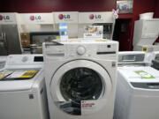 Washing machines are displayed in 2021 at Sam's Appliances TV & Furniture in Norwood, Mass. The decision replace or repair a broken appliance isn't always simple.