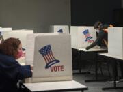 A temporary worker for the Clark County Elections Office cleans a voting space in 2020.