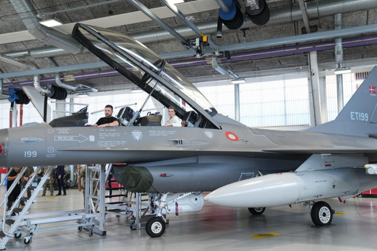 Ukrainian President Volodymyr Zelenskyy, left, and Denmark's Prime Minister Mette Frederiksen sit in a F-16 fighter jet at Skrydstrup Airbase, in Vojens, Denmark, Sunday, Aug. 20, 2023.