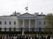 FILE - People walk past the White House in Washington, Tuesday, March 28, 2023. Unflattering portraits of both President Joe Biden and former President Donald Trump emerge clearly in a new poll by The Associated Press-NORC Center for Public Affairs Research, which asked an open-ended question about what comes to mind when people think of them.