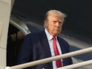 FILE - Former President Donald Trump steps off his plane as he arrives at Hartsfield-Jackson Atlanta International Airport, Thursday, Aug. 24, 2023, in Atlanta.