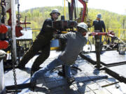 FILE - Workers move a section of well casing into place at a Chesapeake Energy natural gas well site near Burlington, Pa., in Bradford County, on April 23, 2010. A team of that has spent four years studying the health effects of natural gas fracking in southwestern Pennsylvania is set to present its findings Tuesday, Aug. 15, 2023.