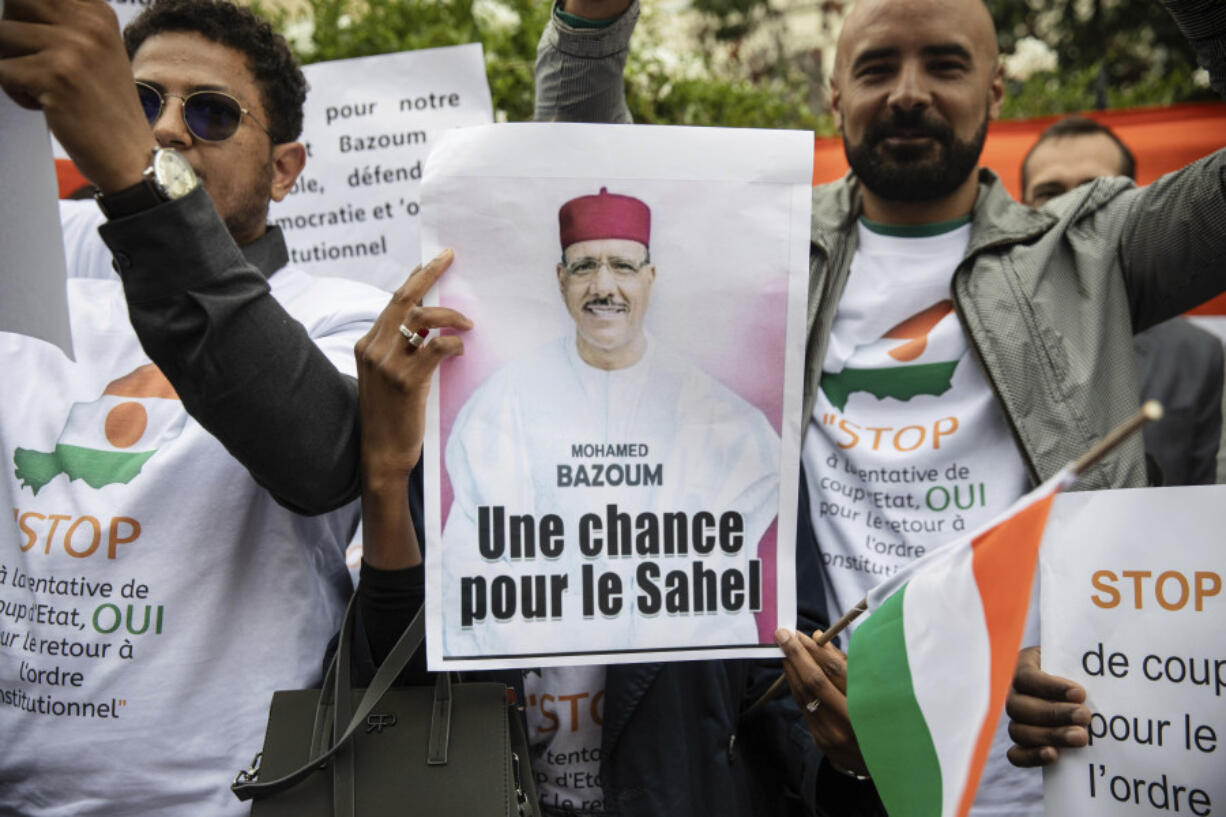 Demonstrators gather in front of the Embassy of Niger in Paris, in support of Nigerien President Mohamed Bazoum and ECOWAS, Saturday, Aug. 5, 2023.