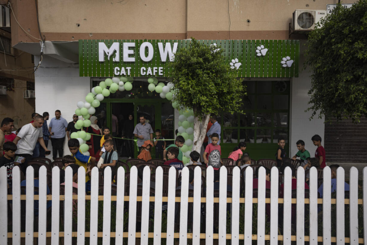 Palestinians gather for the opening ceremony of Meow Cafe in Gaza City, Thursday, Aug 17, 2023. Amidst the challenges of life in the Gaza Strip, constrained by a 17-year blockade and ongoing conflicts, this first-ever cat cafe offers a unique space for relaxation and positive human-animal interaction.