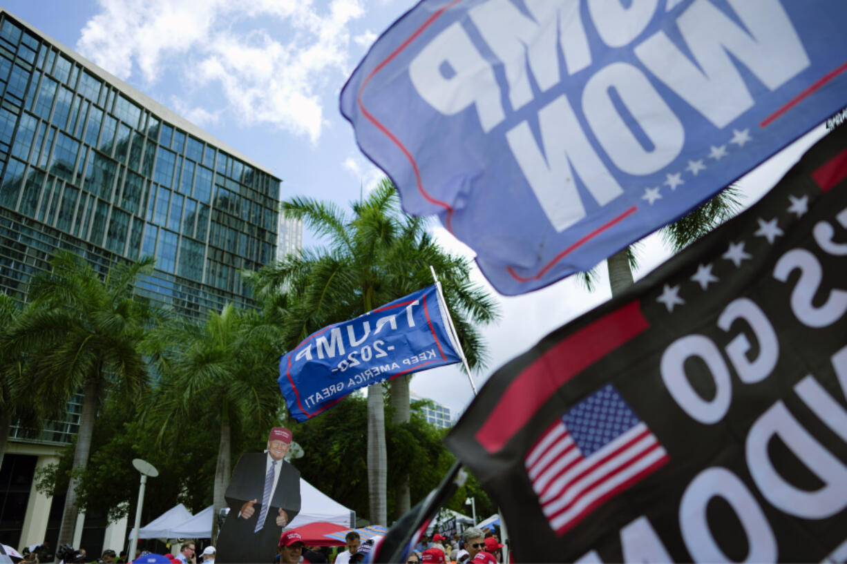 FILE - A poster of former President Donald Trump and banners are held up by supporters in front of the Wilkie D. Ferguson Jr. U.S. Courthouse, Tuesday, June 13, 2023, in Miami.