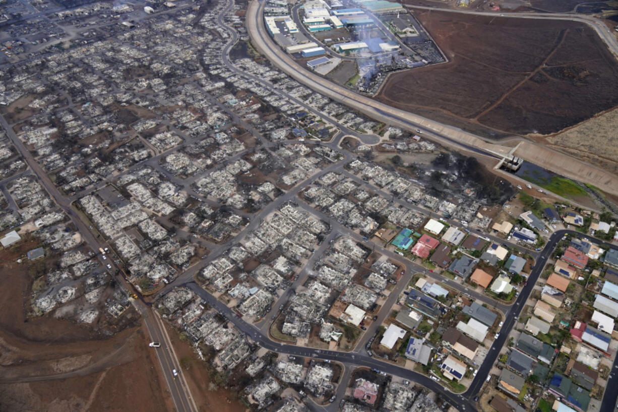 FILE - Wildfire wreckage is seen Thursday, Aug. 10, 2023, in Lahaina, Hawaii. With a housing crisis that has priced out many Native Hawaiians as well as families that have been there for decades, concerns are rising that Maui could become the latest example of "climate gentrification," when it becomes harder for local people to afford housing in safer areas after a climate-amped disaster.