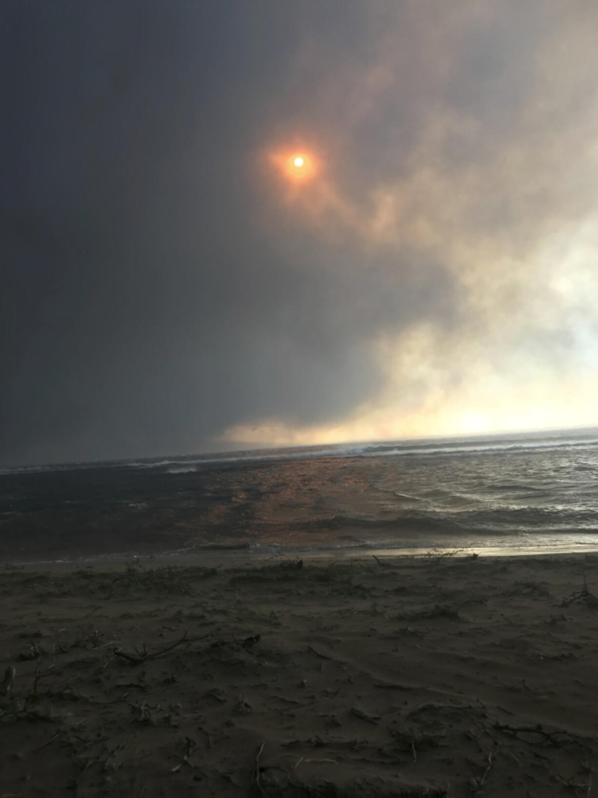 In this photo provided by Anne Landon, smoke fills the sky and blots out the sun as a deadly fire overtakes the town of Lahaina, on the Hawaiian island of Maui, Tuesday, Aug. 8, 2023. The lahaina resident was able to escape her senior apartment complex with her life. But many people, families, homes and an entire town were lost in the inferno.